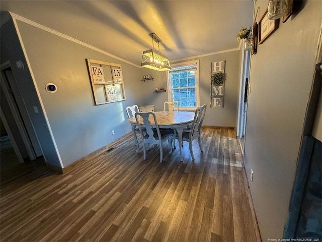 dining space featuring dark hardwood / wood-style flooring and crown molding