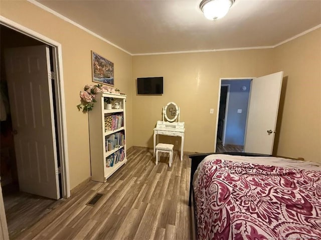 bedroom featuring crown molding and wood-type flooring