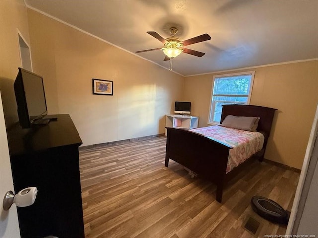 bedroom with lofted ceiling, wood-type flooring, ornamental molding, and ceiling fan