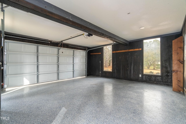 garage with wood walls and a garage door opener