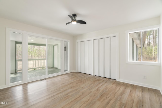 unfurnished bedroom featuring ceiling fan, access to outside, baseboards, and light wood-style flooring