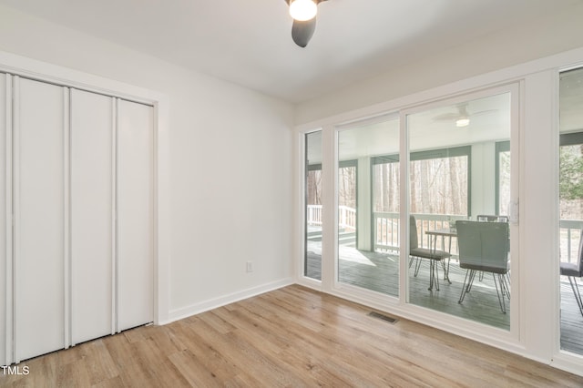 unfurnished bedroom with access to exterior, light wood finished floors, visible vents, a ceiling fan, and baseboards