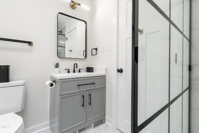 full bathroom featuring toilet, a shower with shower door, baseboards, and vanity