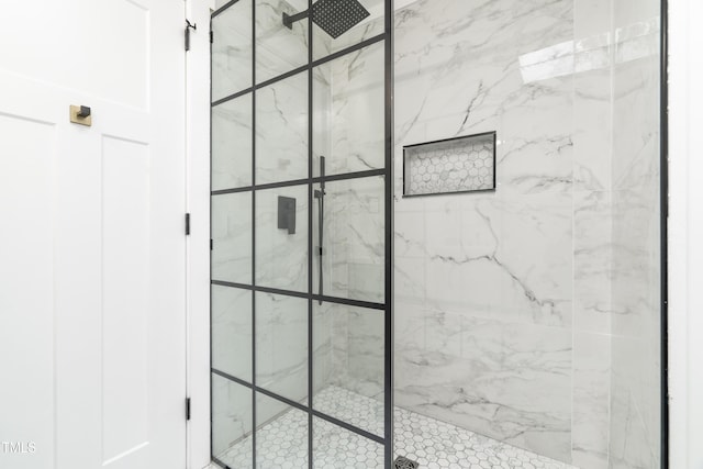 bathroom featuring a marble finish shower