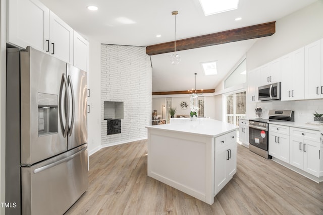 kitchen with vaulted ceiling with beams, light wood-style floors, appliances with stainless steel finishes, and light countertops