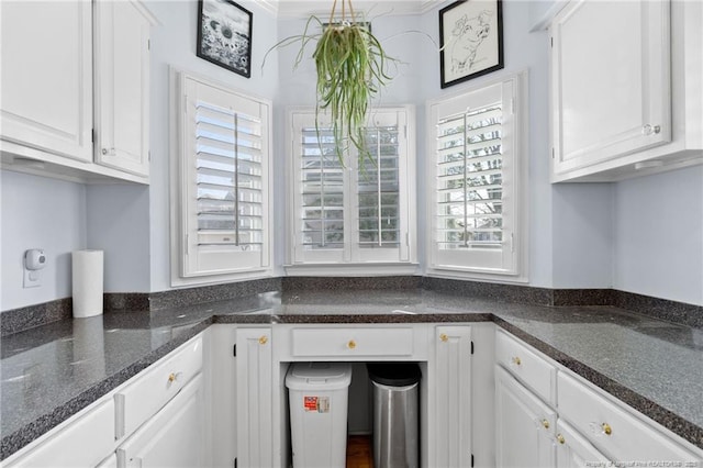 kitchen featuring white cabinetry and dark stone counters