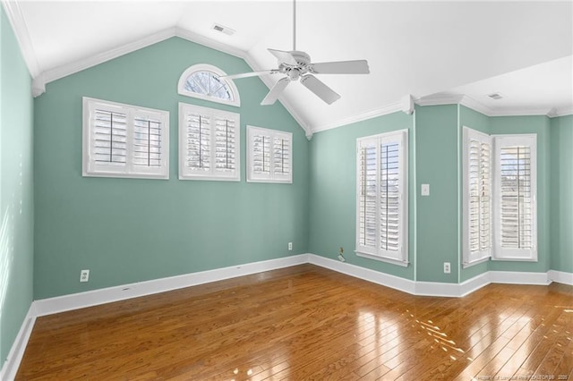 empty room with crown molding, vaulted ceiling, hardwood / wood-style floors, and ceiling fan