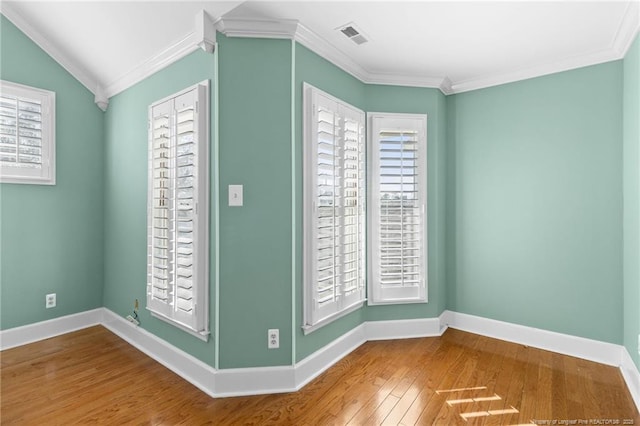 unfurnished room featuring hardwood / wood-style floors, ornamental molding, and a healthy amount of sunlight