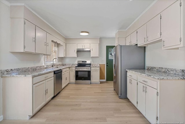 kitchen featuring crown molding, stainless steel appliances, light wood-style flooring, a sink, and under cabinet range hood