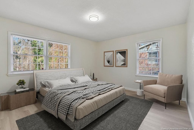 bedroom with baseboards and light wood-style floors