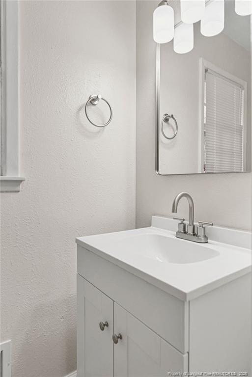 bathroom with a textured wall and vanity