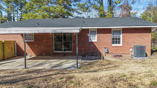 back of property featuring a patio, brick siding, roof with shingles, and central AC unit