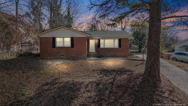 view of front of house featuring entry steps, brick siding, and fence