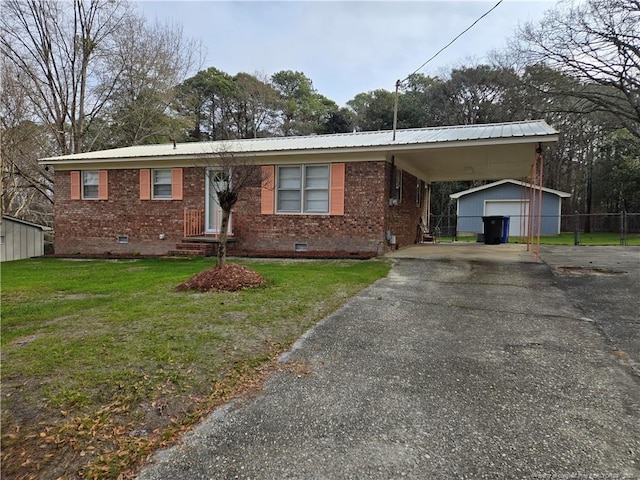 view of front of home featuring a garage, an outbuilding, and a front lawn