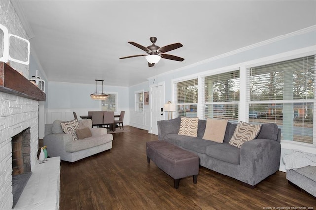 living room with dark hardwood / wood-style flooring, ornamental molding, and ceiling fan