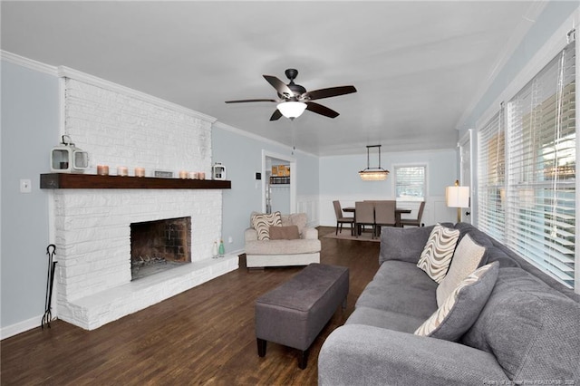 living room with dark hardwood / wood-style flooring, crown molding, a fireplace, and ceiling fan