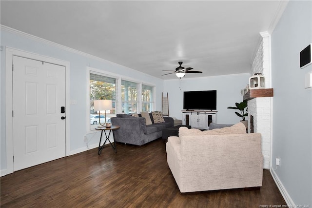 living room with a fireplace, dark wood-type flooring, ornamental molding, and ceiling fan