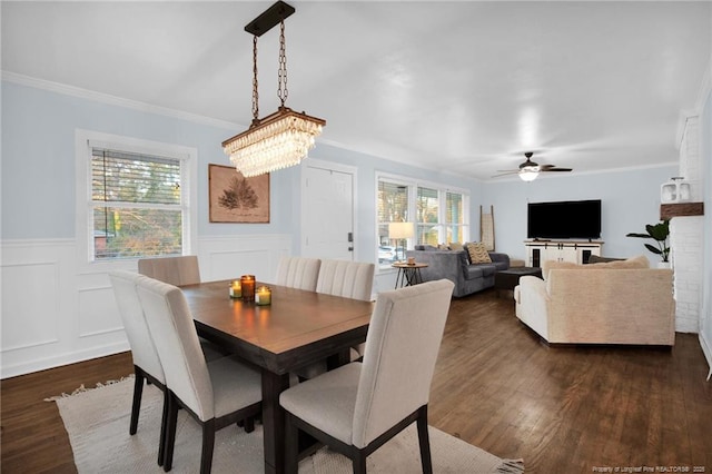 dining space featuring ornamental molding, ceiling fan with notable chandelier, and dark hardwood / wood-style flooring