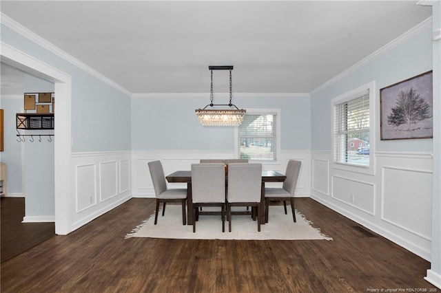 dining space with ornamental molding, dark hardwood / wood-style flooring, and a chandelier