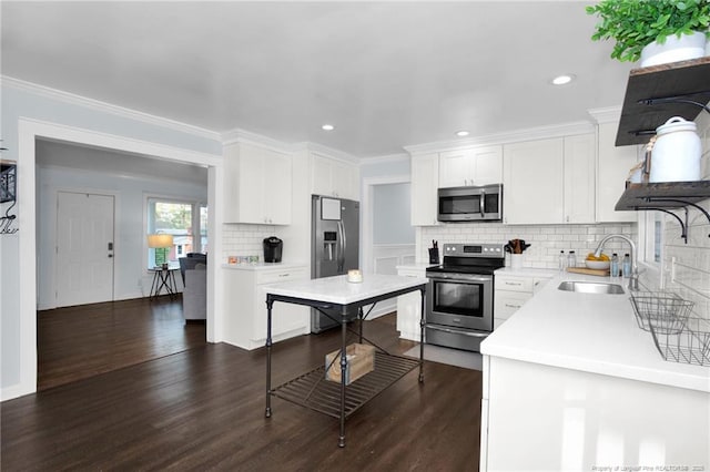 kitchen featuring appliances with stainless steel finishes, sink, white cabinets, dark hardwood / wood-style flooring, and ornamental molding