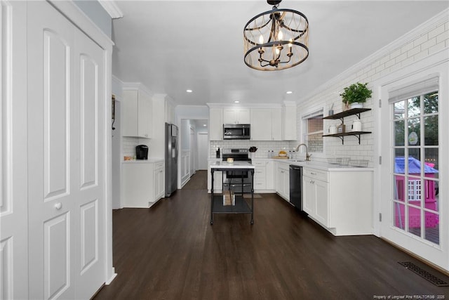 kitchen featuring dark wood-type flooring, sink, white cabinetry, crown molding, and stainless steel appliances