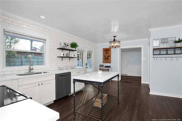 kitchen featuring sink, white cabinets, hanging light fixtures, ornamental molding, and stainless steel dishwasher