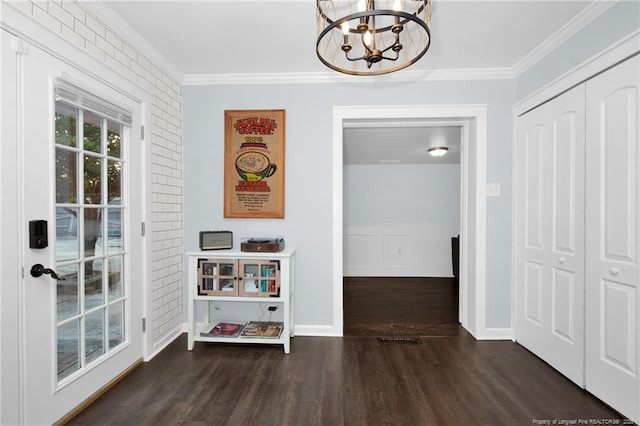 hallway featuring ornamental molding, brick wall, dark wood-type flooring, and a notable chandelier