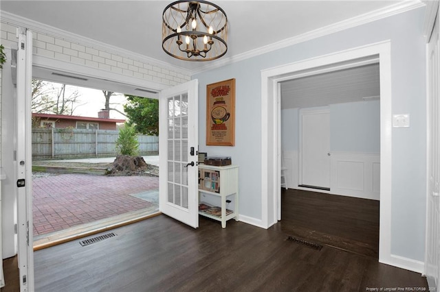 doorway with dark hardwood / wood-style flooring, a notable chandelier, crown molding, and french doors