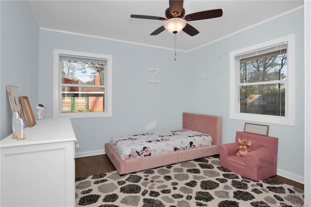 bedroom featuring crown molding, dark wood-type flooring, and ceiling fan