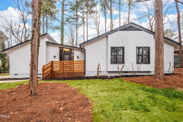 view of front facade with a front lawn and a deck