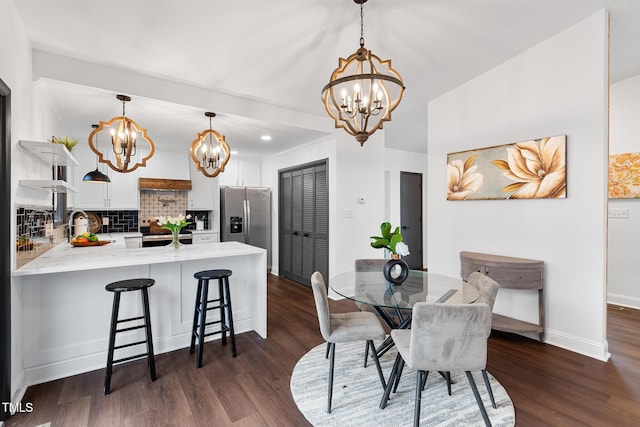 dining space with dark wood-type flooring and a notable chandelier