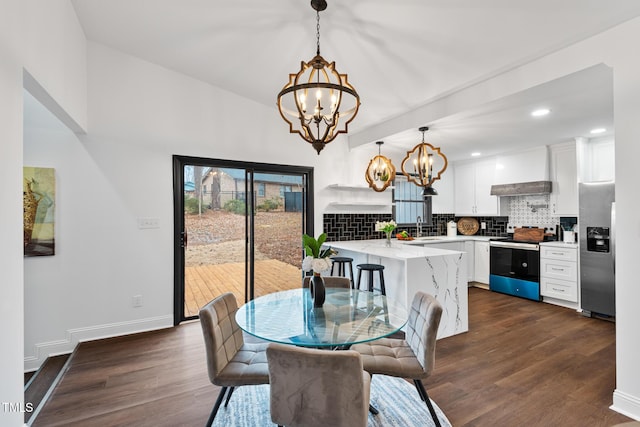 dining space with dark hardwood / wood-style flooring, sink, and a chandelier