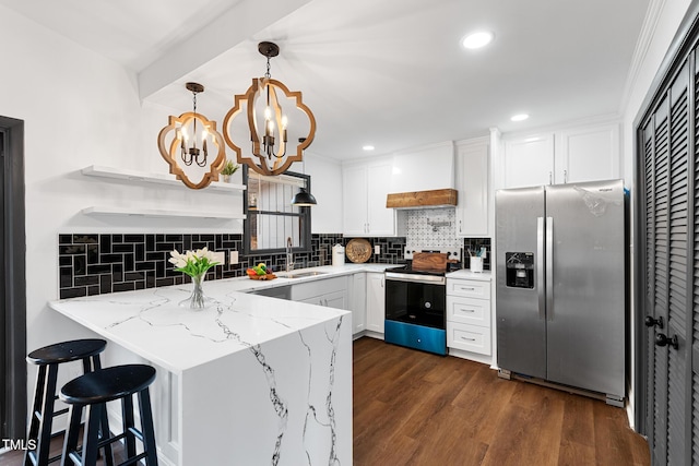 kitchen with white cabinets, hanging light fixtures, kitchen peninsula, stainless steel appliances, and custom range hood