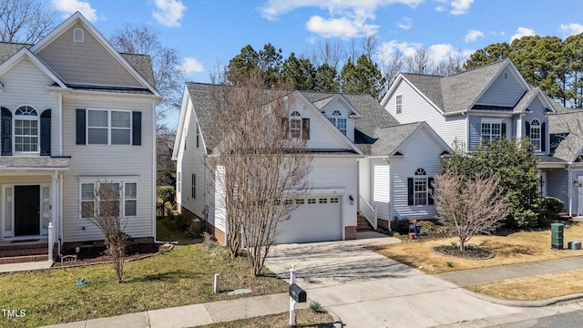 traditional home with a shingled roof, a front yard, crawl space, and driveway