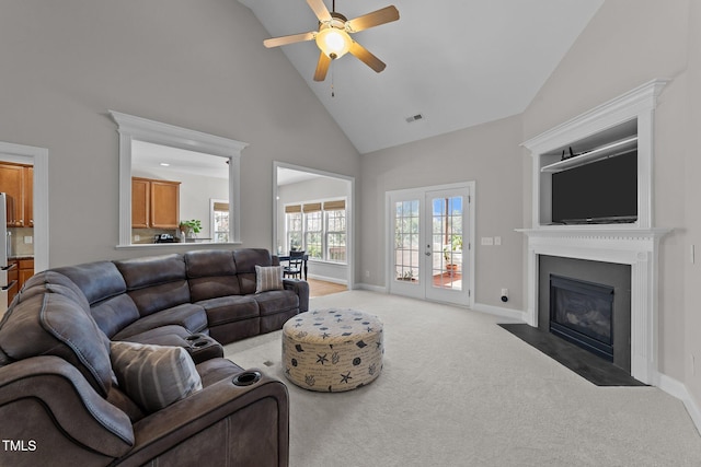 living area with light carpet, a fireplace with flush hearth, visible vents, baseboards, and french doors