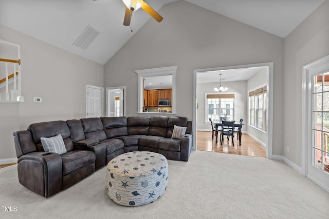 living area with light carpet, high vaulted ceiling, baseboards, and visible vents