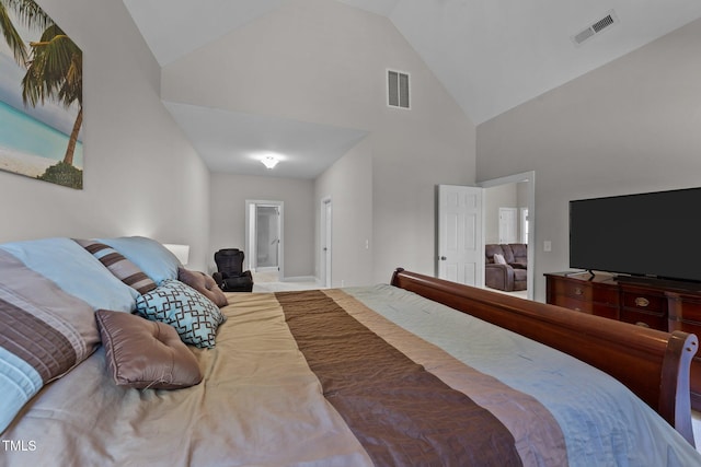 bedroom with ensuite bathroom, high vaulted ceiling, and visible vents