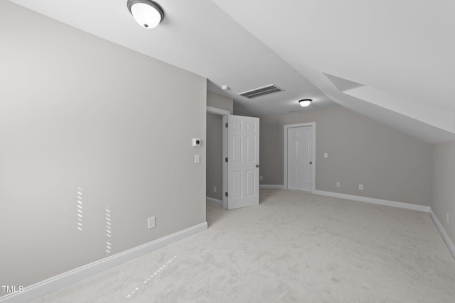 additional living space with vaulted ceiling, carpet flooring, visible vents, and baseboards