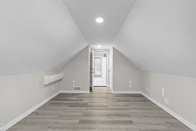 bonus room featuring lofted ceiling, visible vents, baseboards, and wood finished floors