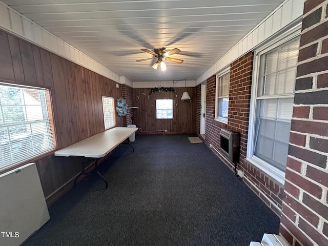 unfurnished sunroom with ceiling fan and heating unit