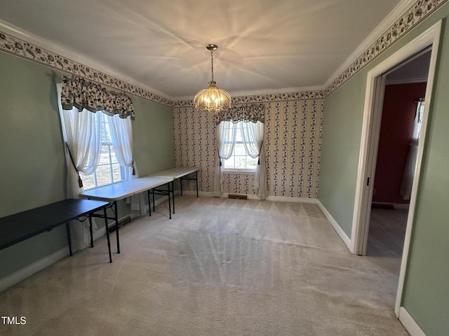 unfurnished dining area featuring ornamental molding, carpet flooring, and a chandelier