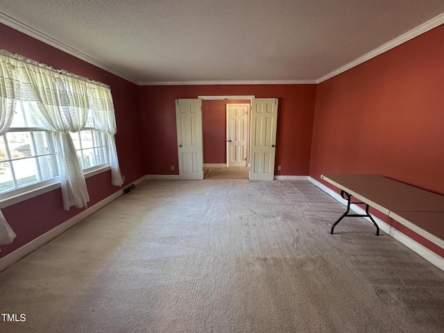 carpeted empty room featuring ornamental molding and a textured ceiling