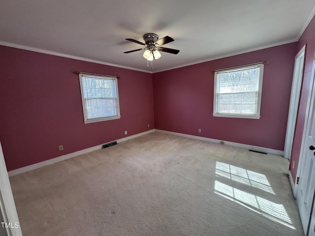 spare room with crown molding, ceiling fan, and light carpet