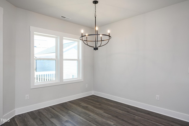 unfurnished room with an inviting chandelier and dark wood-type flooring