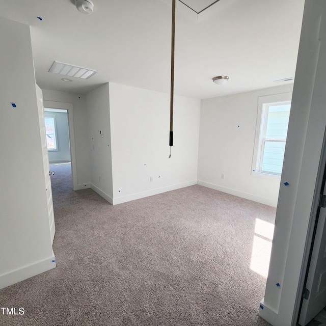 spare room featuring visible vents, carpet, and baseboards