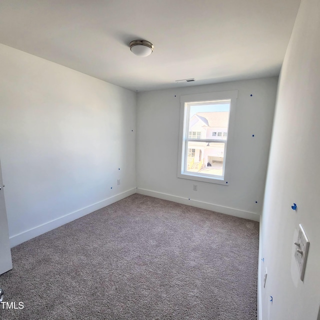 unfurnished room featuring carpet flooring, visible vents, and baseboards