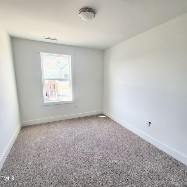 carpeted empty room featuring visible vents and baseboards