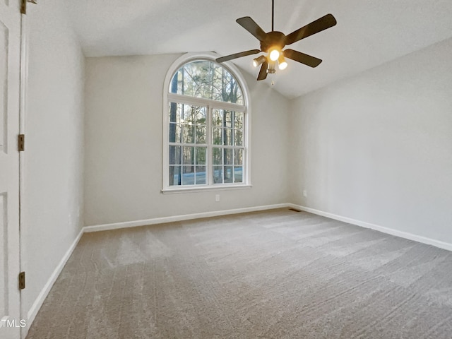 carpeted empty room featuring vaulted ceiling and ceiling fan