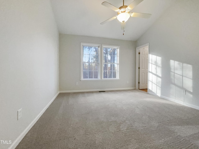 empty room featuring vaulted ceiling, ceiling fan, and carpet floors