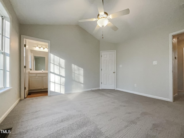 unfurnished bedroom featuring ceiling fan, lofted ceiling, connected bathroom, and carpet floors